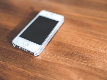 Weißes Smartphone auf einem Holztisch