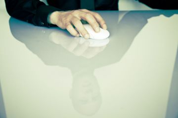 Großaufnahme: Hand auf der Maus am Schreibtisch