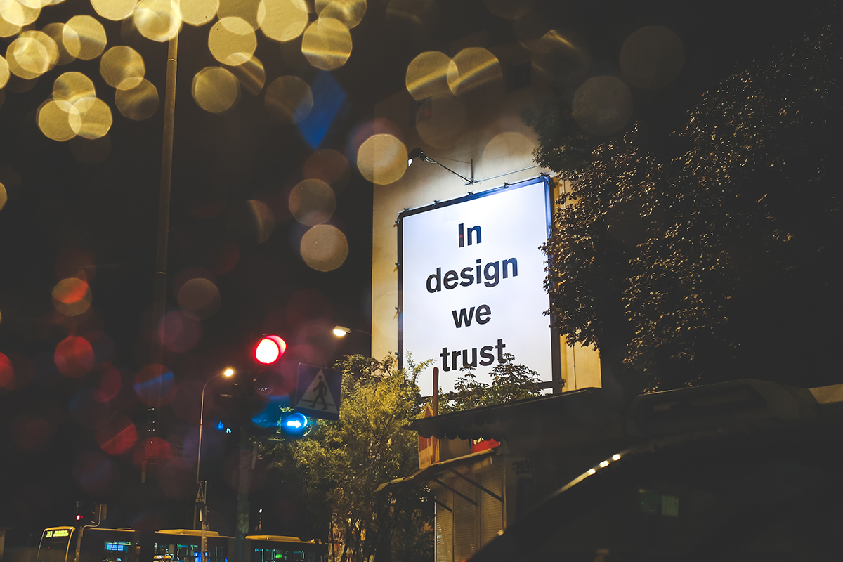 Werbetafel an einer Wand: "In design we trust."