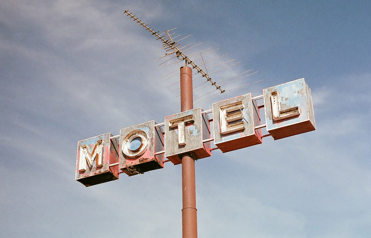 Veraltete Leuchtreklame eines Motels vor blauem Himmel